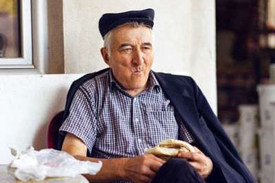 Portrait of man wearing hat while sitting at home