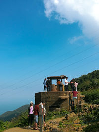 People at observation point against blue sky