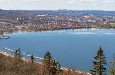 High angle view of townscape by sea against sky