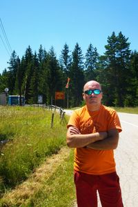 Young man wearing sunglasses standing by plants