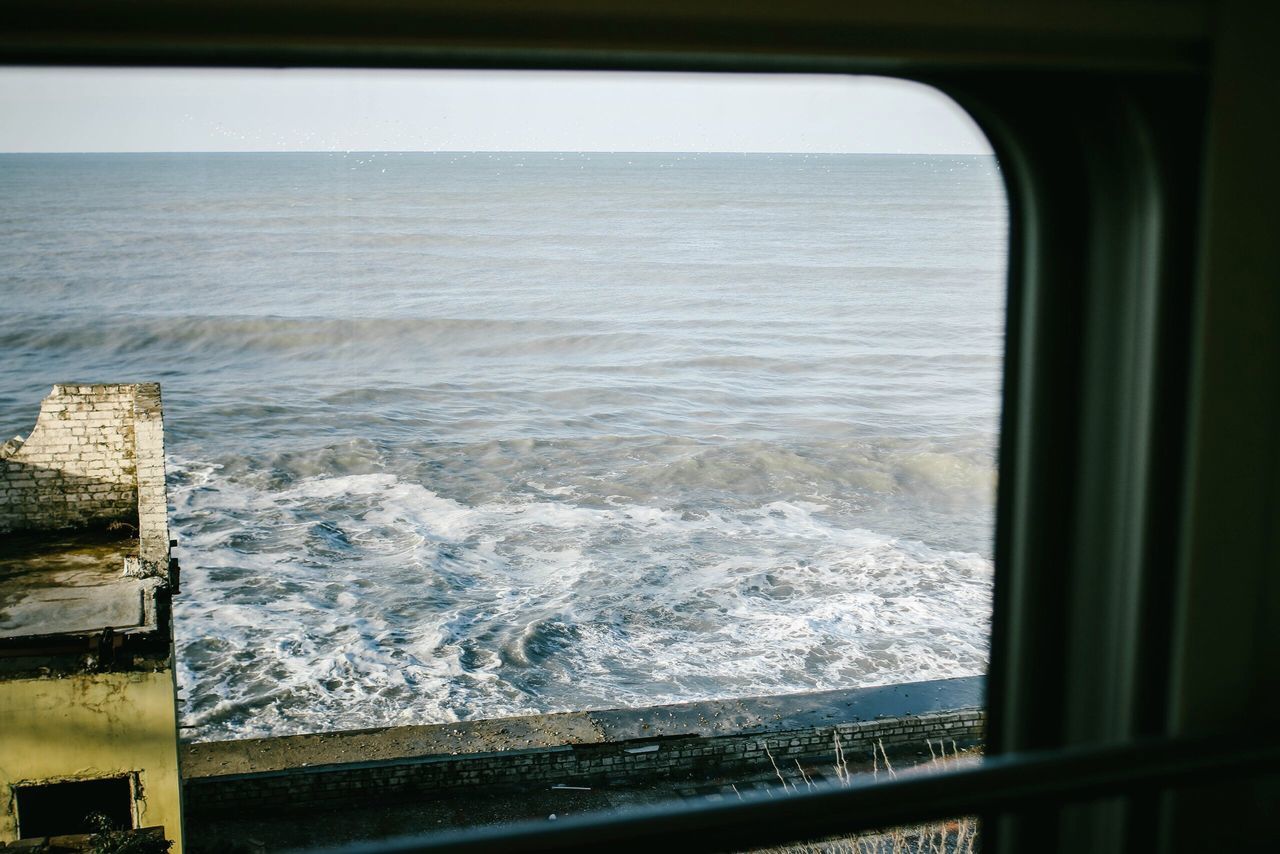 SEA AGAINST SKY SEEN THROUGH WINDOW