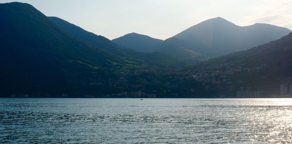 Scenic view of sea and mountains against sky