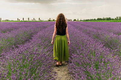 Rear view of woman walking on field