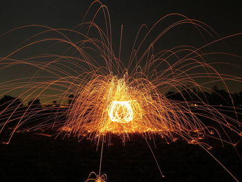 Firework display against sky at night