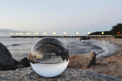 Close-up of illuminated rock on beach against clear sky