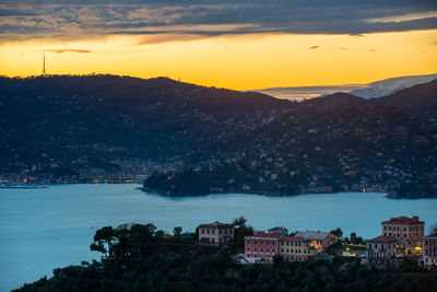 High angle view of townscape by sea against sky during sunset