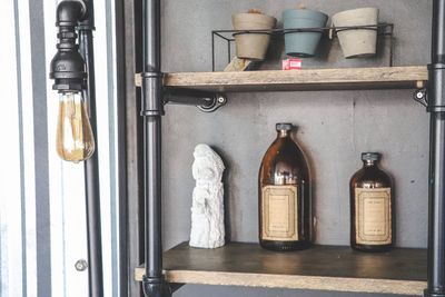 Various bottles on shelf against wall
