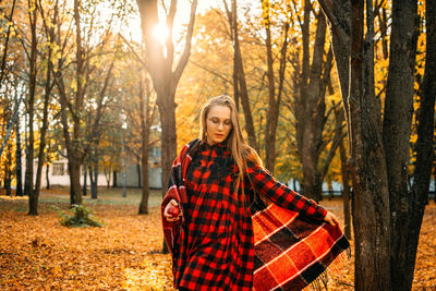 Life style portrait of happy woman in fall park. beautiful girl on the nature picnic camping. 