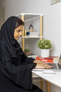 Side view of young woman using mobile phone