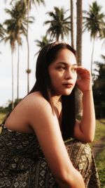 Portrait of smiling young woman sitting at nature 