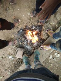 Low section of people standing by bonfire