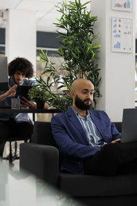 Portrait of young man using laptop while sitting on sofa