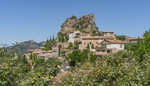 Buildings in town against clear blue sky