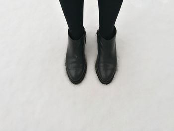 Low section of woman standing on snow