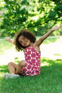 Portrait of young woman sitting on grassy field