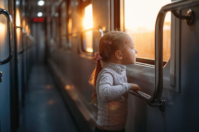 Rear view of girl sitting in train