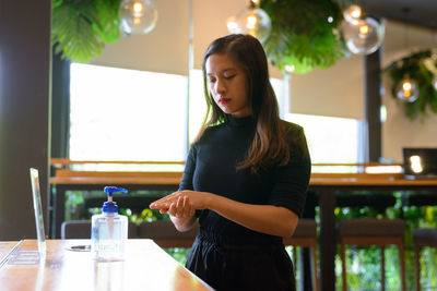 Young woman standing at restaurant table