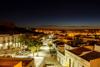 High angle view of illuminated buildings against sky at night