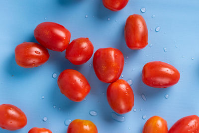 Close-up of wet cherries against blue background