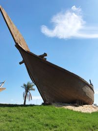 Low angle view of traditional windmill on field against sky