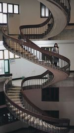 Woman standing on spiral staircase of building