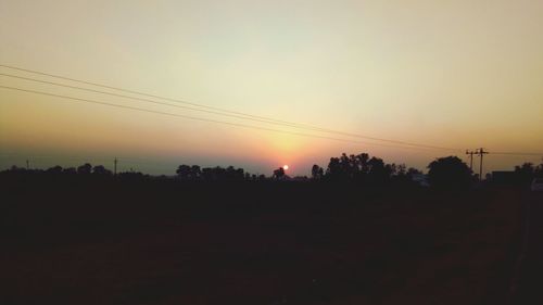 Silhouette trees against sky during sunset