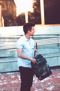 University student with backpack while standing outdoors