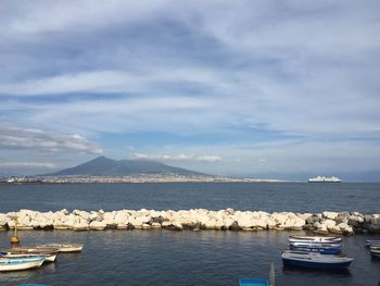 Boats moored on sea against sky