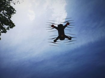 Low angle view of silhouette drone flying against sky