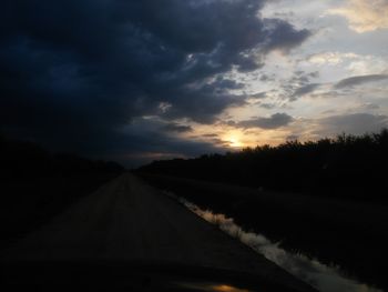 Country road against cloudy sky