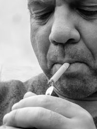 Close-up of mature man burning cigarette