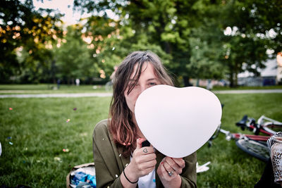 Portrait of girl holding balloons in park