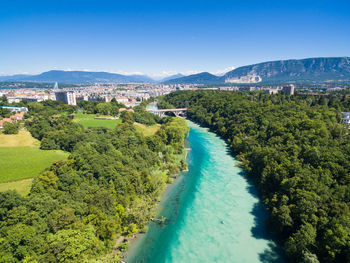 Aerial view of river amidst trees against clear blue sky