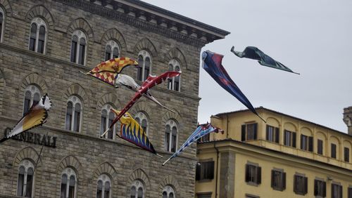 Low angle view of flags hanging on building against sky