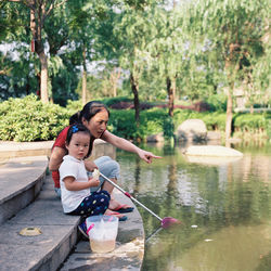 Side view of young woman sitting in water