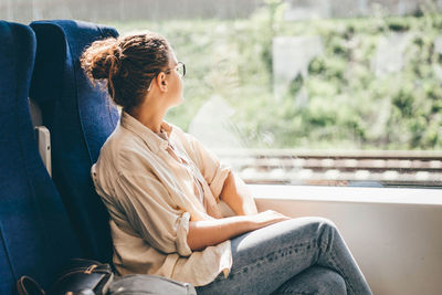 Rear view of woman sitting on bench