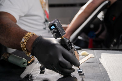 Midsection of man repairing car