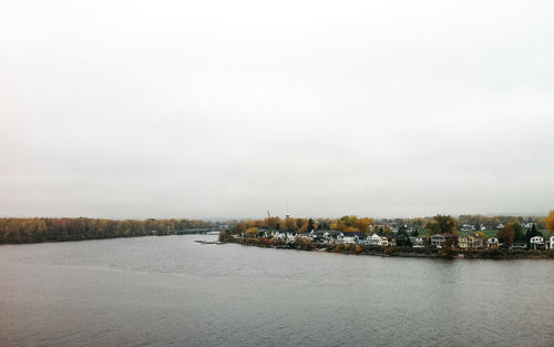 Scenic view of lake and town against sky