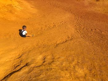 High angle view of baby boy sitting at desert