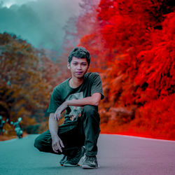 Portrait of boy sitting in park during autumn