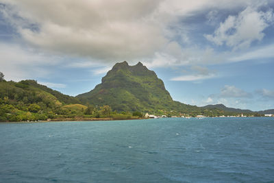 Scenic view of sea and mountains against sky