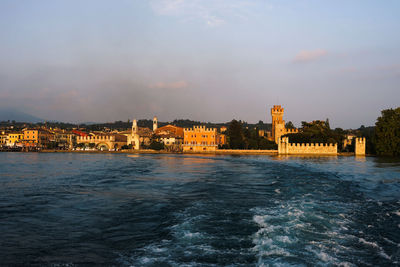 View of buildings in sea against cloudy sky