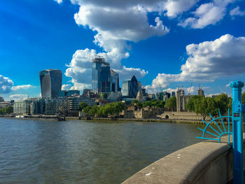 Buildings in city against cloudy sky
