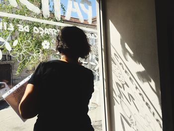 Rear view of people looking through window