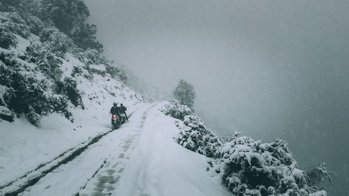 People riding in snow on motorbikes