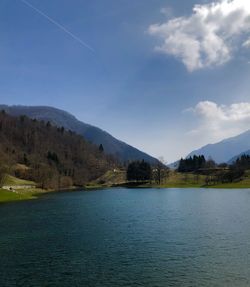 Scenic view of lake by mountains against sky