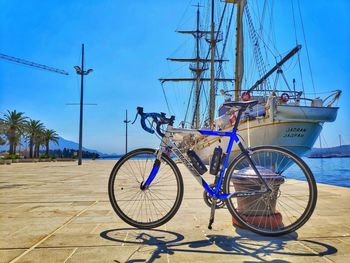 Bicycles on pole by sea against blue sky