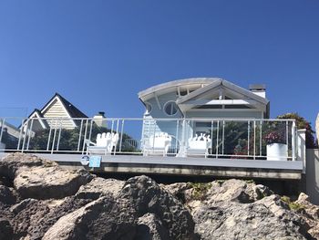 Low angle view of rocks against clear blue sky