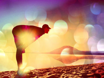 Digital composite image of silhouette woman standing by sea against sky during sunset