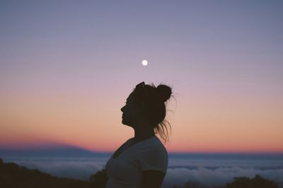 Silhouette woman standing against sky during sunset